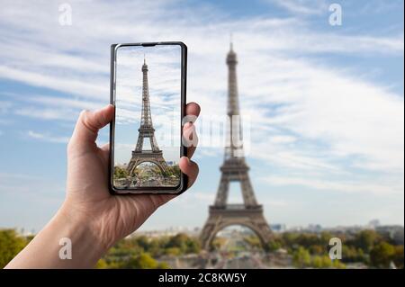 Touriste prenant une photo de la tour Eiffel à Paris, France. Homme tenant le téléphone et prenant des photos. Banque D'Images