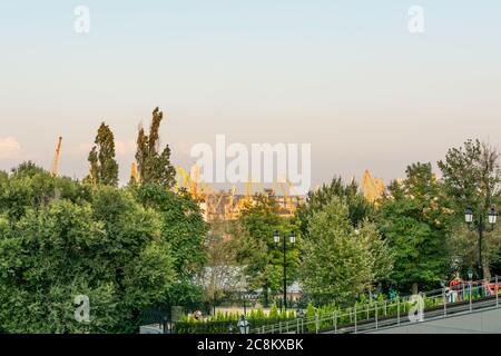 Ukraine, Odessa - 23 août 2019 : les grues du port se montent au-dessus des couronnes d'arbres verts dans le port d'Odessa. Banque D'Images