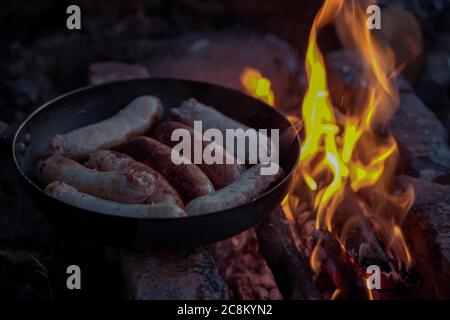 Saucisses de viande hachées grillées, dans une poêle près du feu Banque D'Images