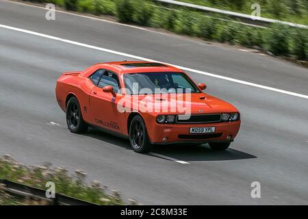 Dodge (USA) Challenger Orange American muscle car conduite sur l'autoroute M6 près de Preston à Lancashire, Royaume-Uni. Banque D'Images