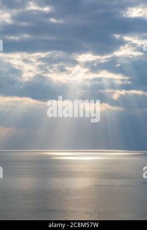 Vue sur l'océan depuis les falaises de Seaford, avec la lumière du soleil qui brille à travers les nuages sur l'eau Banque D'Images