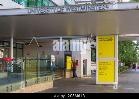 Deux hommes ont une affiche de bienvenue à l'entrée principale de l'Université de Westminster, Marylebone Road, Londres, Angleterre, Royaume-Uni Banque D'Images