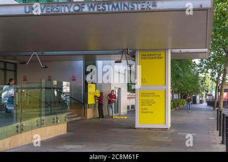 Deux hommes ont une affiche de bienvenue à l'entrée principale de l'Université de Westminster, Marylebone Road, Londres, Angleterre, Royaume-Uni Banque D'Images