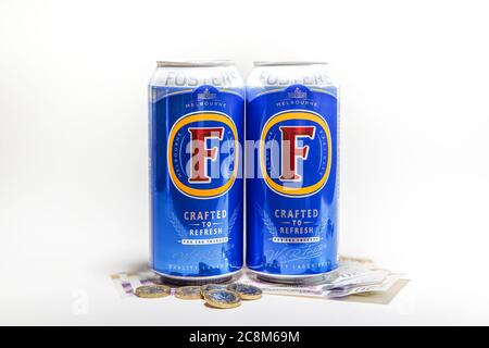 Gros plans de canettes de bière lager isolées sur pile de cash au Royaume-Uni, argent avec fond blanc. Concept de l'argent de bière, de l'argent de boisson, allocation de dépense de bière. Banque D'Images