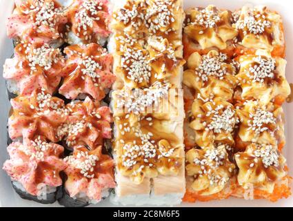 Sushis japonais. Petits pains chauds cuits au four avec thon, saumon, crevettes, crabe et avocat. Vue de dessus de l'assortiment de sushis. Banque D'Images
