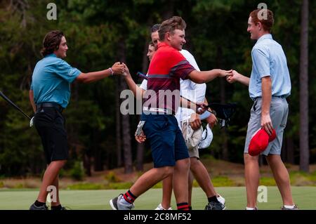 Village de Pinehurst, Caroline du Nord, États-Unis. 25 juillet 2020. ADAM MILLER, de Phoenix, Arizona, à gauche, TYLER JONES, de Jacksonville, Caroline du Nord, centre, Et DANIEL BOONE, de Fuquay Varina, Caroline du Nord, se félicitent mutuellement et leurs caddies après avoir terminé leur dernière partie du championnat du monde de Teen de golf des enfants des États-Unis (Boys 15-18) au célèbre Pinehurst No 2, dans le village de Pinehurst, Caroline du Nord. Chaque année, le Championnat du monde de Teen accueille des golfeurs âgés de 18 à 7 ans dans la région de Pinehurst. Crédit : ZUMA Press, Inc./Alay Live News Banque D'Images