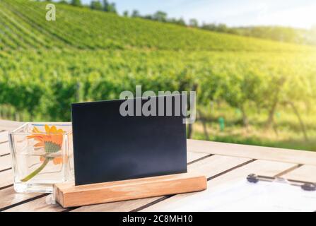 Table avec un modèle de tableau noir contre le vignoble, concept publicitaire Banque D'Images