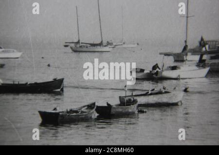 Fin années 70 vintage noir et blanc style de vie photographie d'un tas de bateaux de pêche ancrés dans le port. Banque D'Images