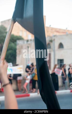 Des milliers de militants du « drapeau noir » protestent contre Benyamin (Bibi) Netanyahou qui fait face à 3 accusations de corruption devant les tribunaux israéliens. Les manifestants prétendent qu'une personne corrompue ne peut pas être Premier ministre. Netanyahou (AKA crime Minister) fait tout son possible pour se maintenir à son poste et retarder sa journée au tribunal, y compris en utilisant l'actuelle pandémie mondiale pour lutter pour sa survie personnelle. Photographié sur la rue Yefet à Jaffa, Israël, le 25 2020 juillet Banque D'Images