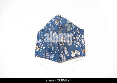 Masque facial en tissu floral bleu et blanc pour la protection contre le coronavirus (COVID-19) et d'autres maladies infectieuses. Isolé sur fond blanc. Banque D'Images