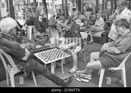 Des hommes chinois âgés ou retraités de souche à Kreta Ayer Square, Chinatown, Singapour, ont été engrosés ou en partie dormant pendant une partie d'échecs chinois Banque D'Images