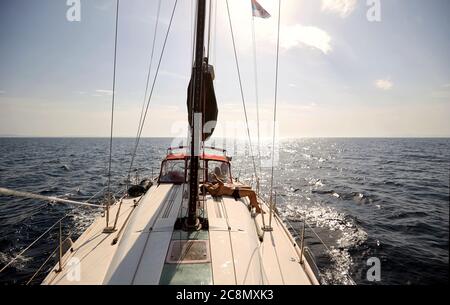 Jeune couple prenant un bain de soleil sur un yacht sur la mer ouverte Banque D'Images