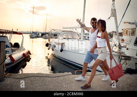 Un jeune couple apprécie le coucher du soleil et une promenade sur le quai Banque D'Images