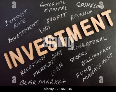 Texte d'investissement affiché sur un tableau noir avec un mot 3d sur la texture de la surface d'éducation sombre. Banque D'Images