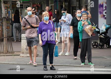 Belgrade, Serbie - 16 juillet 2020 : personnes portant des masques chirurgicaux debout au carrefour et attendant de traverser la rue de la ville Banque D'Images