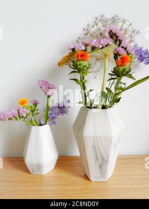 Petit bouquet de fleurs sauvages de printemps dans des vases en faux marbre Banque D'Images