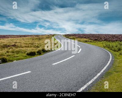Une route de tarmac serpentant dans les landes par une journée ensoleillée. Banque D'Images