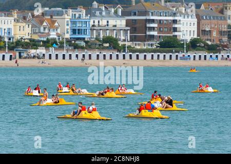 Weymouth, Dorset, Royaume-Uni. 26 juillet 2020. Météo Royaume-Uni. Vacanciers sur pédalos s'appréciant sur l'eau à la station balnéaire de Weymouth à Dorset, un matin de soleil brumeux chaud. Crédit photo : Graham Hunt/Alay Live News Banque D'Images