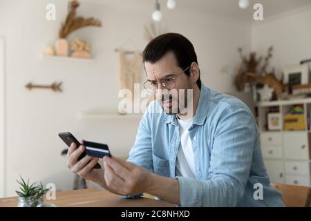 Un homme malheureux a des problèmes de paiement avec la carte de crédit en ligne Banque D'Images