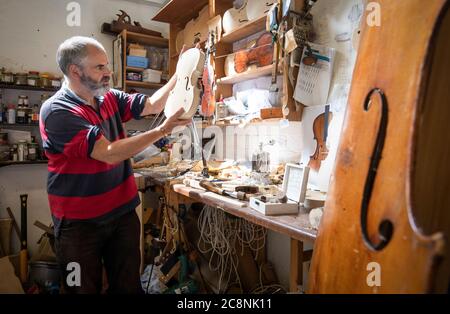 Luthier Steve Burnett, dans son atelier de Haymarket, Édimbourg, apporte la touche finale à un violon unique sur lequel il travaille pendant son confinement en hommage à l'écrivain Robert Louis Stevenson et pour souligner le 170e anniversaire depuis la naissance de l'auteur d'Édimbourg, célèbre dans le monde entier. Banque D'Images