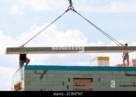 Ouvrier du constructeur installant un panneau de dalle de sol en béton sur le chantier de construction du bâtiment. Installation de dalle de sol en béton au deuxième étage Banque D'Images