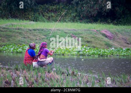 village womans poissons sur la rivière Banque D'Images