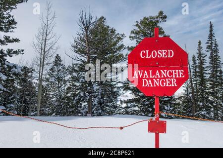 Panneau rouge vif indiquant fermé : risque d'avalanche dans la neige à une station de ski avertissement de risque dans l'arrière-pays. Banque D'Images