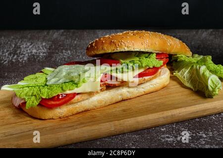 Sandwich maison avec jambon, fromage, bacon, tomates et salade Banque D'Images