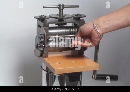 Bijoutier au travail, le procédé de laminage d'un fil d'argent dans un atelier de bijouterie. Banque D'Images