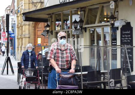 Un homme et une femme âgés portant des masques en public en Angleterre suite à une loi adoptée rendant obligatoire le port de couvertures de visage dans les magasins Banque D'Images