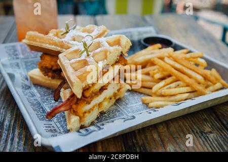 Sandwich au poulet et aux gaufres frits avec bacon et frites Banque D'Images