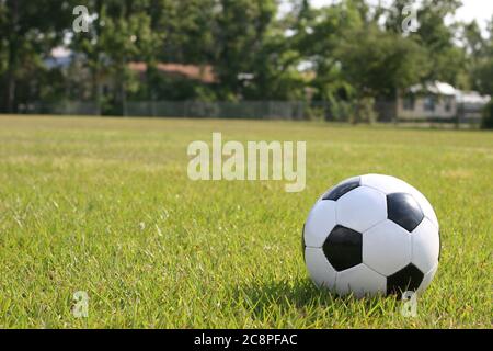 Ballon de football posé dans l'herbe verte prête à être joué. Banque D'Images