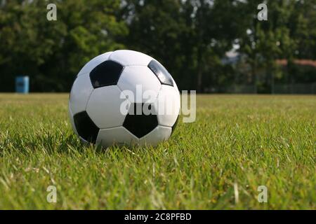 Ballon de football posé dans l'herbe verte prête à être joué. Banque D'Images