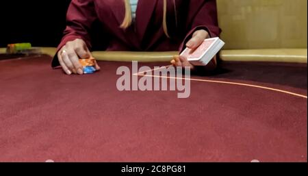 Séance concessionnaire dans un casino à la table tout en maintenant les cartes et la distribution Banque D'Images