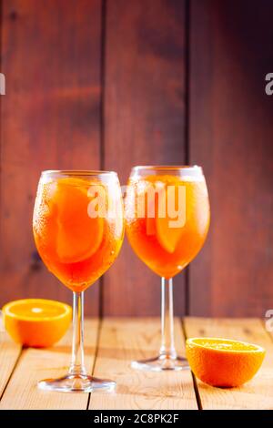 Apéritif spritz sur fond de bois. Deux verres d'aperol spritz avec des lamelles d'orange. Cocktail d'été en verre. Boisson tendance. Style rustique Banque D'Images