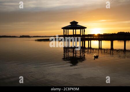 Lever de soleil sur un belvédère dans un petit lac dans une communauté de retraite du centre de la Floride Banque D'Images