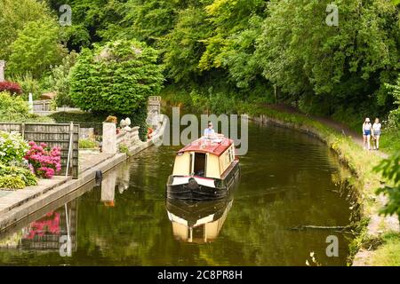 Llanfoist, pays de Galles - juillet 2020 : bateau étroit sur le canal de Brecon et Abergavenny. Deux jeunes marchent sur la piste de remorquage. Banque D'Images