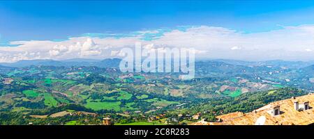 Dessin aquarelle du plan d'antenne vue panoramique du paysage avec vallée, collines vertes, champs et villages de la République de Saint-Marin suburbain avec ciel bleu nuages blancs. Vue depuis la forteresse de Saint-Marin. Banque D'Images