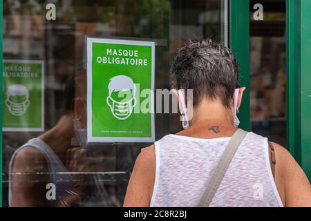 Montréal, CA - 26 juillet 2020 : une signalisation indiquant que des masques ou des revêtements non médicaux sont requis pour entrer dans le magasin Banque D'Images