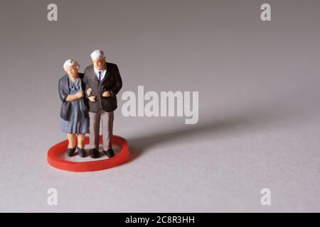 Personnes âgées debout sur un cercle rouge. Photographie conceptuelle de personnes miniatures Banque D'Images