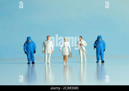 Vue de face des médecins, des infirmières et des travailleurs médicaux portent un costume bleu noisette qui se présente au travail. Photographie conceptuelle de personnes miniatures. Banque D'Images