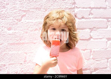 Les enfants mangent de la glace rose. Enfant mangeant de glace. Banque D'Images