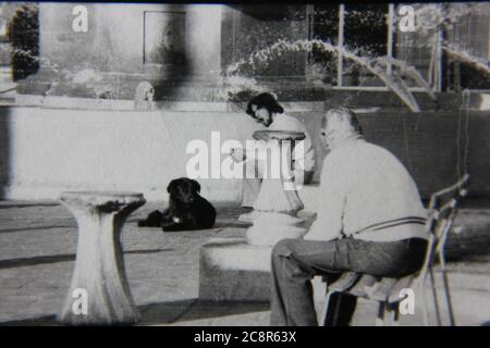 Belle photo de style de vie noir et blanc vintage des années 70 d'un vieil homme assis dans le parc public local. Banque D'Images
