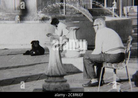 Belle photo de style de vie noir et blanc vintage des années 70 d'un vieil homme assis dans le parc public local. Banque D'Images