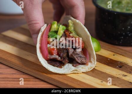 Barbecue mexicain, tacos de carne asada et chorizo avec guacamole et salsas maison Banque D'Images