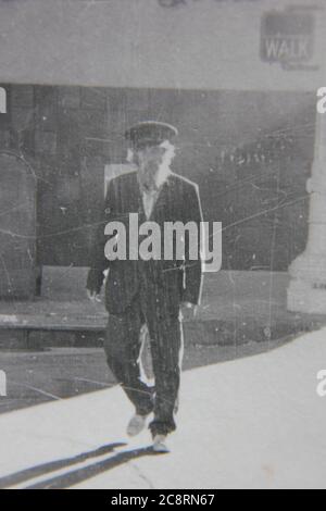 Belle photo de style de vie noir et blanc vintage des années 70 d'un homme âgé pour sa promenade matinale. Banque D'Images