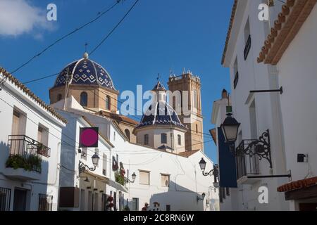 Notre Dame de Solace Église avec des dômes carrelés de bleu vus à travers l'allée ensoleillée de la vieille ville d'Altea, Costa Blanca, Espagne Banque D'Images