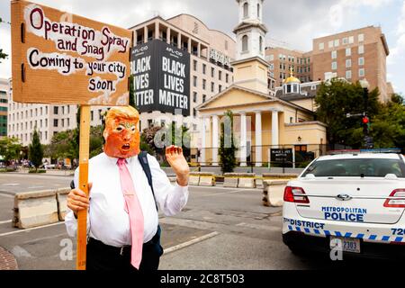 Un homme imitant Trump à Black Lives Matter Plaza tient un panneau qui dit "opération Spray et snag venir à votre ville bientôt" Washington, DC, États-Unis Banque D'Images