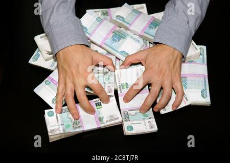 Grande pile de billets, roubles russes, billets de 1000 roubles. Les mains accaparent de l’argent. Soif d'argent. Banque D'Images