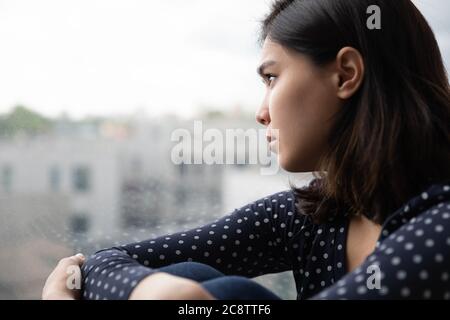 Triste fille vietnamienne regarder dans la fenêtre manque de réflexion Banque D'Images
